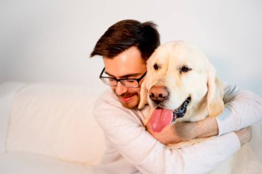 Adam köpeğiyle oynuyor.