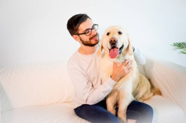 Adam köpeğiyle oynuyor.