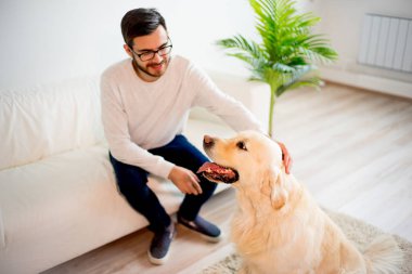 Adam köpeğiyle oynuyor.