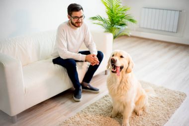 Adam köpeğiyle oynuyor.