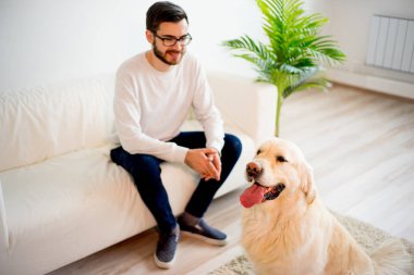 Adam köpeğiyle oynuyor.