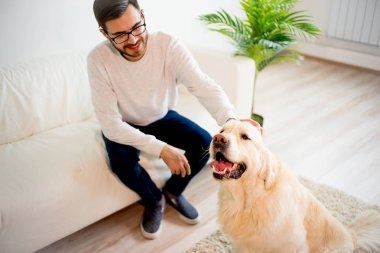 Adam köpeğiyle oynuyor.