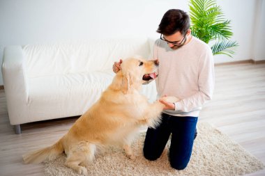 Adam köpeğiyle oynuyor.