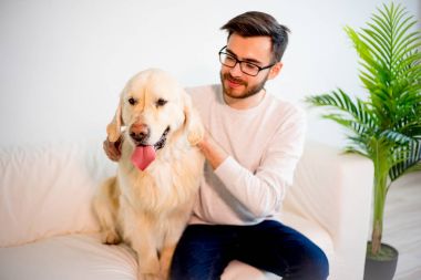 Adam köpeğiyle oynuyor.