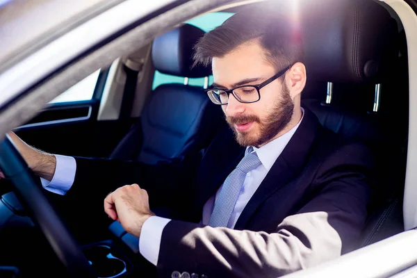 Zakenman tijd in auto controleren — Stockfoto