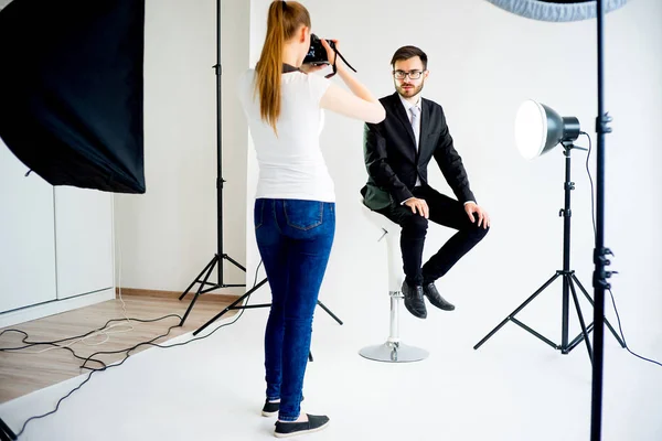 Fotógrafa tomando fotos de un modelo masculino en estudio — Foto de Stock