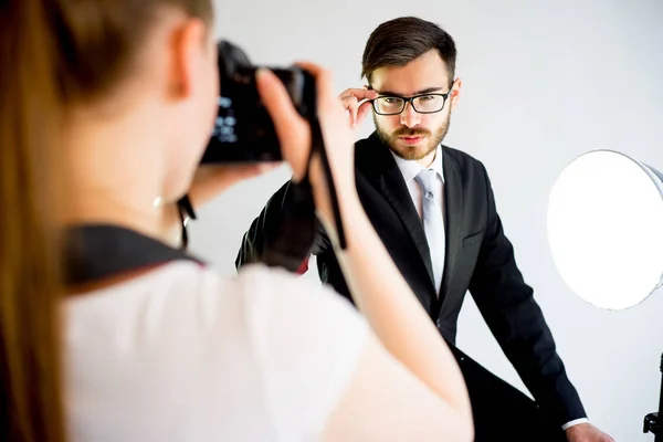 Fotógrafa tomando fotos de un modelo masculino en estudio — Foto de Stock