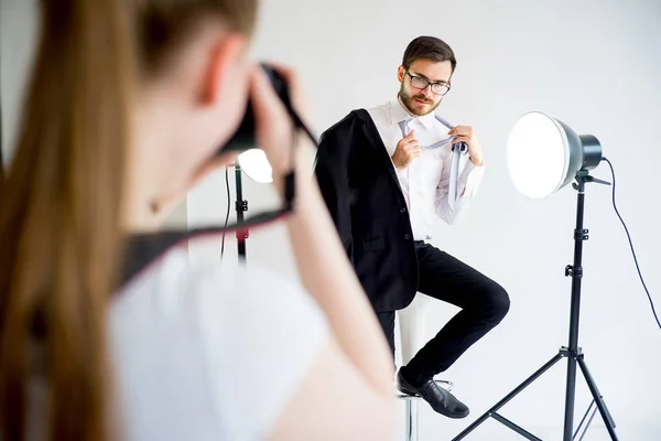 Fotógrafa tomando fotos de un modelo masculino en estudio — Foto de Stock