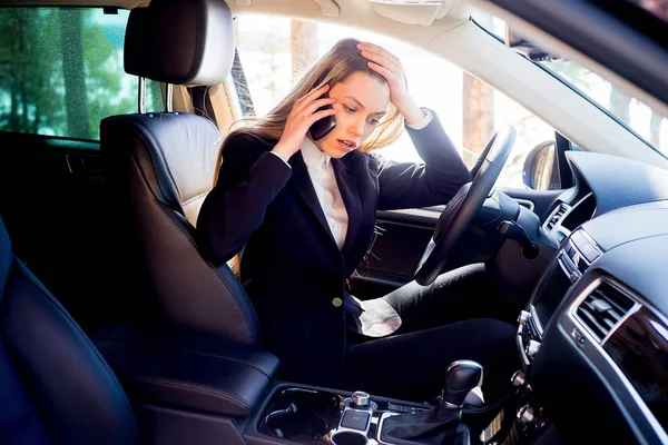 Стрессовая деловая женщина в машине — стоковое фото