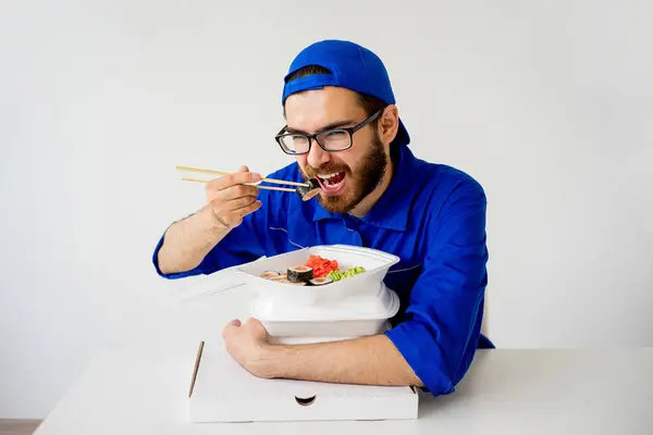 Delivery man eating sushi — Stock Photo, Image