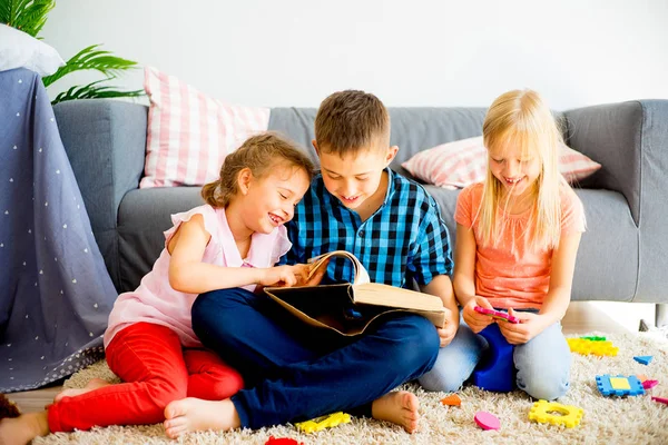 Three siblings reading a book — Stock Photo, Image