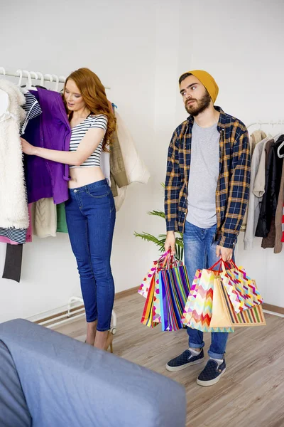 Entediado homem compras com sua namorada — Fotografia de Stock