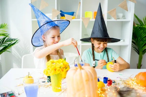 Dos chicas pintando calabazas — Foto de Stock