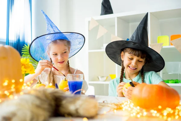 Dos chicas pintando calabazas — Foto de Stock