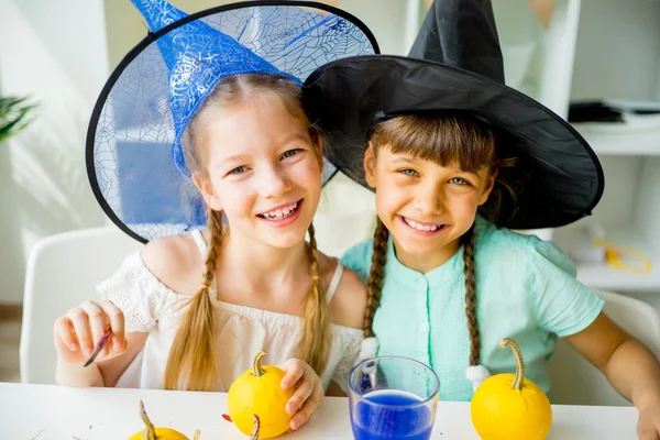 Dos chicas pintando calabazas —  Fotos de Stock