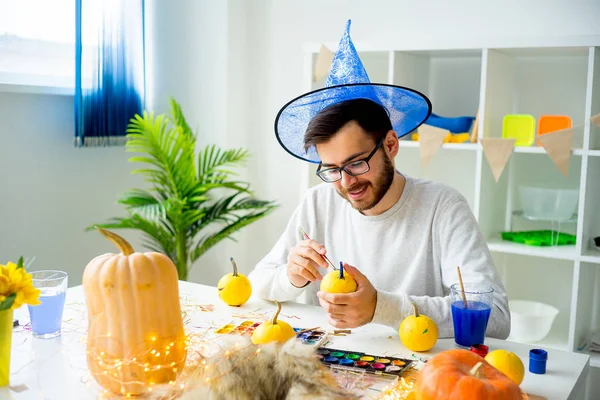 Guy painting pumpkins — Stock Photo, Image