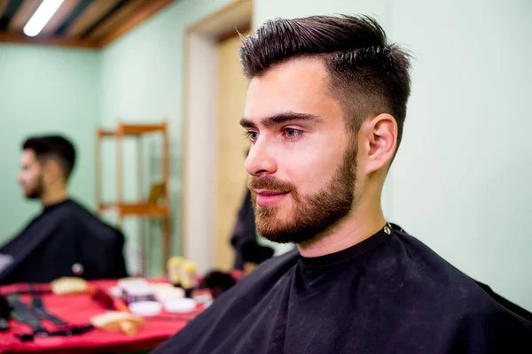Un tipo guapo en una barbería — Foto de Stock