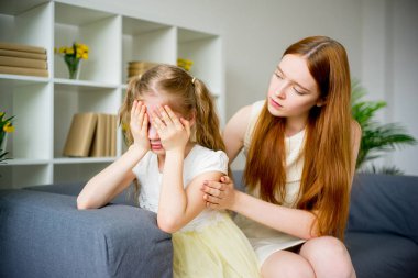 Anne kızını teselli ediyor.