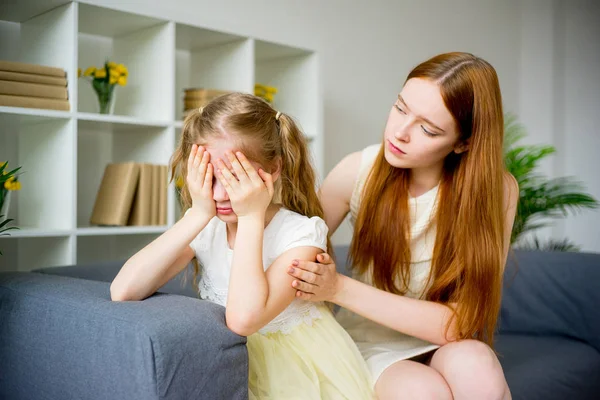 Anne kızını teselli ediyor.