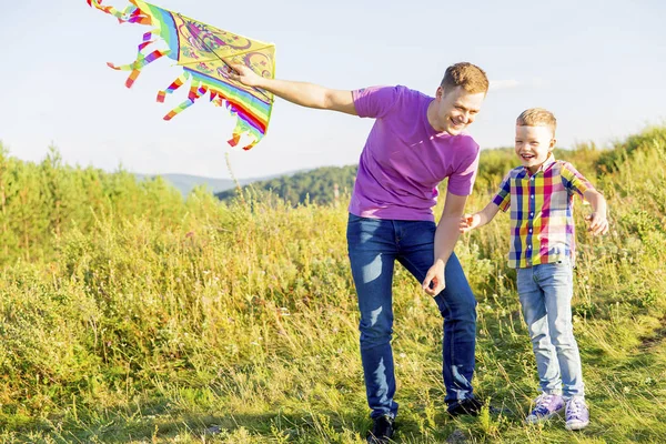 Vater und Sohn spielen mit einem Drachen — Stockfoto