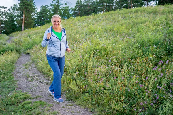 Bejaarde vrouw sport buiten doen — Stockfoto