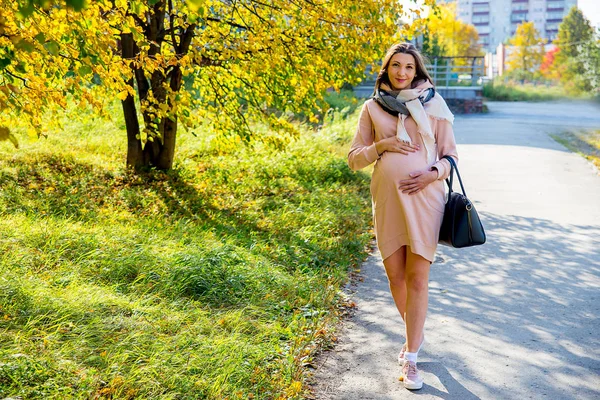 妊娠中の女性が公園を歩いて — ストック写真