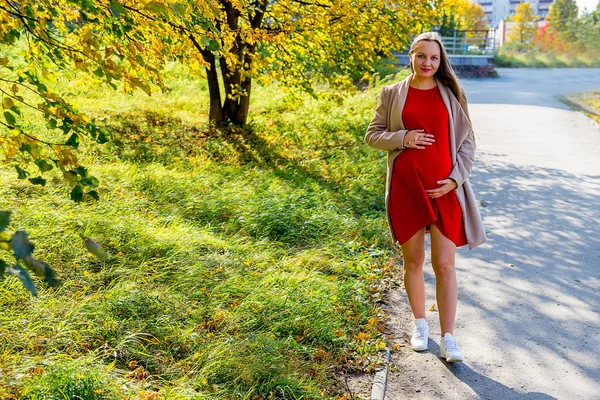 Mulher grávida andando em um parque — Fotografia de Stock
