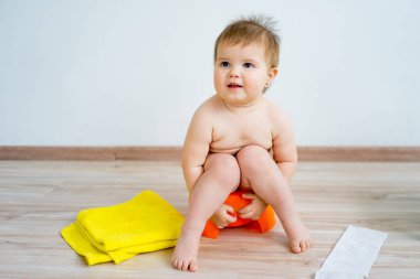 Bir lazımlık üzerinde oturan bebek