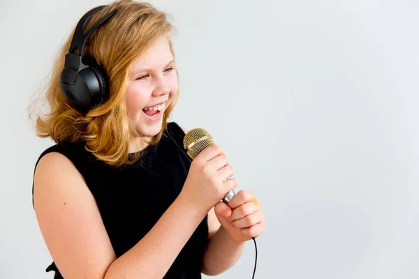 Menina cantando com um microfone — Fotografia de Stock