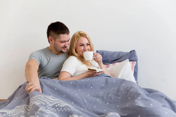 Pareja disfrutando del desayuno en la cama — Foto de Stock