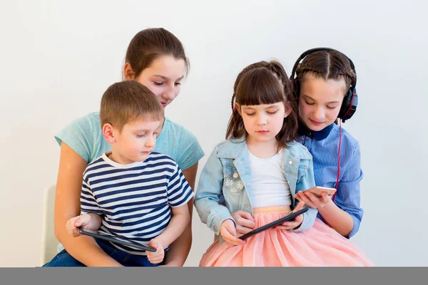 Niños usando diferentes aparatos — Foto de Stock