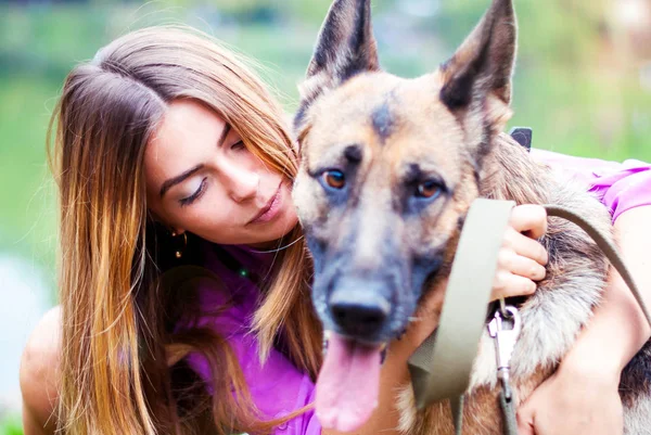 The girl kisses a shepherd. Beautiful woman with a dog. — Stock Photo, Image