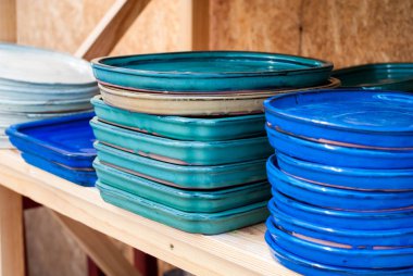 Renkli seramik kaplamalar. Ahşap arka plan üzerinde çiçekler için altlıklar.