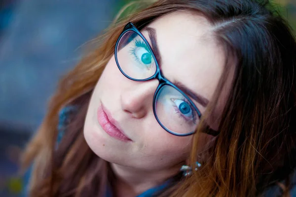 Sorglig vacker flicka i glasögon med blå ögon. — Stockfoto