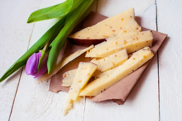 Dutch cheese with fenugreek and walnuts on a wooden table with a tulip. — Stock Photo, Image