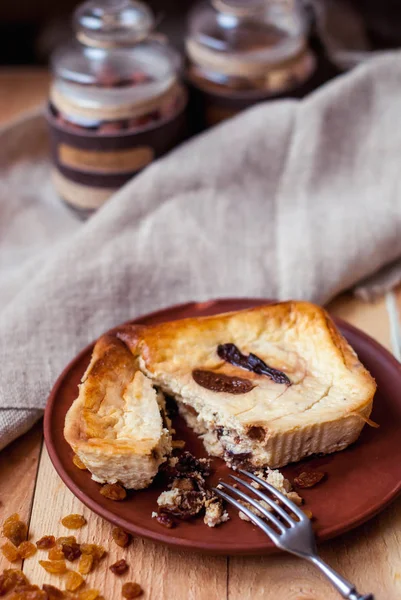 Güveç cottage cheese incir ile ve bir bardak süt ile kuru üzüm. İncir ve süt ile peynirli kek. Cupcake ahşap arka plan üzerinde çilek ile.