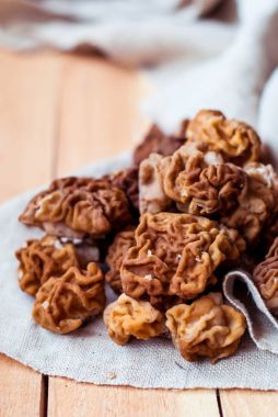 Mantar morel bir keten masa örtüsü ve ahşap arka plan.