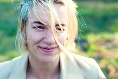 Güzel sarışın kız gülümsüyor günbatımında.