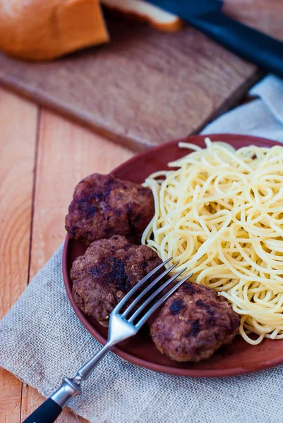 Beşamel sos spagetti bir rustik tarzı ile. Sığır eti mitbols kil tabakta makarna ile.