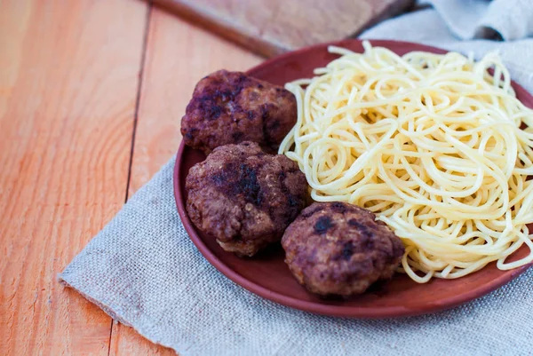 Beşamel sos spagetti bir rustik tarzı ile. Sığır eti mitbols kil tabakta makarna ile.