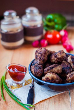 Dana pirzola sebze ve sos ile. Ketçap ve yeşil soğanlı köfte. Köfte bir rustik tarzda bir kaba ahşap tablo.