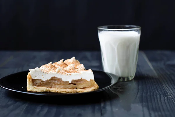 Elmalı turta ve kefir karanlık bir arka plan üzerinde. Bir bardak süt ve elmalı turta. Armut pasta ve yoğurt ahşap bir masa üzerinde.
