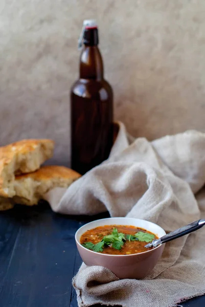 Грузинский суп харчо с лаваш. Национальное блюдо грузинского харчо. Суп харчо с кинзой и овощами на деревянном столе . — стоковое фото