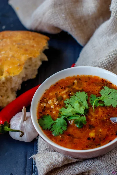 Georgische Suppe kharcho mit lavash. Nationalgericht georgischer harcho. Suppe kharcho mit Koriander und Gemüse auf einem Holztisch. — Stockfoto