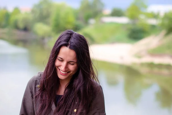 Egy gyönyörű lány, hosszú sötét haj, nevetés, a folyó közelében smink nélkül. — Stock Fotó
