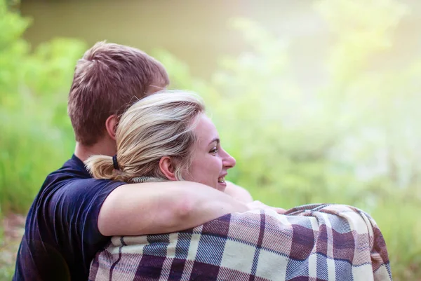 Lovers man and woman embrace in a plaid in the sunset. — Stock Photo, Image