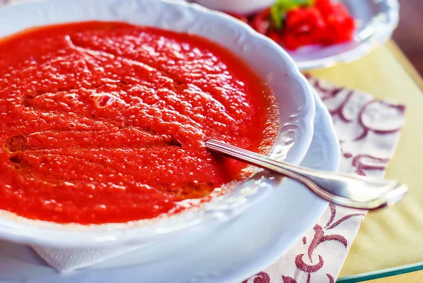 Sildi domates ve beyaz bir tabakta sebze soğuk İspanyol gazpacho çorbası.