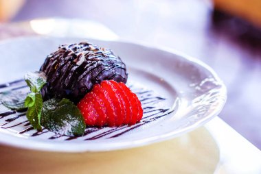 Çilek ve nane bir çelenk arka planda ile çikolatalı kek.