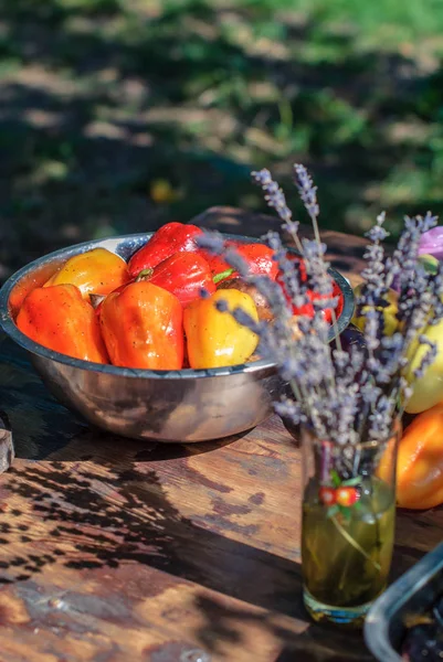 Red and yellow salad peppers in marinade for grilling and a bouquet of lavender on the summer table — Stock Photo, Image