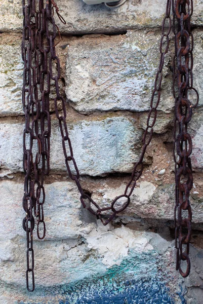 An old brick wall and a rusty chain on it for the background. — Stock Photo, Image